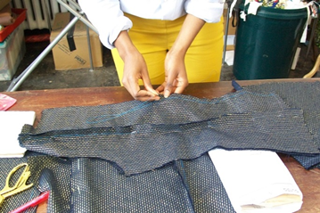 Person sewing fabric on table
